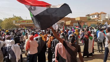 A Sudanese demonstrator waves a national flag during a protest against the October 2021 military coup, in the capital Khartoum, on January 13, 2022. (AFP)