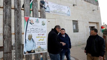 Men stand next to a poster of Palestinian Omar Abdalmajeed As'ad, 80, in Jiljilya village in the Israeli-occupied West Bank, Jan. 12, 2022. (Reuters)