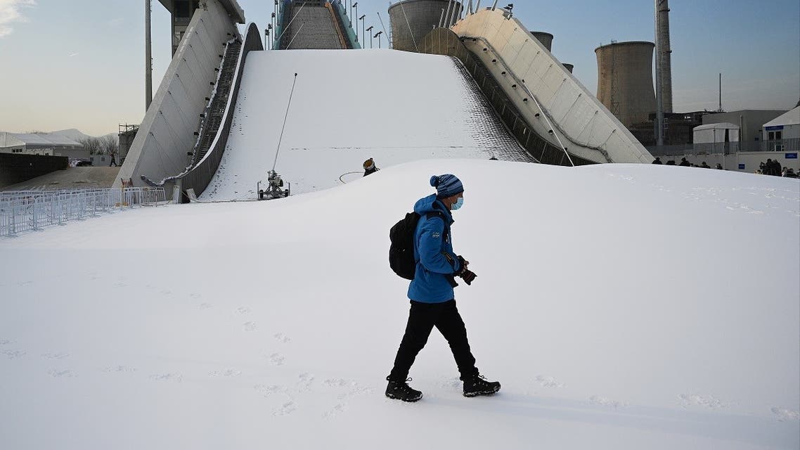 A journalists walks past the Shougang Big Air venue, which will host the big air freestyle skiing and snowboarding competitions at the Beijing 2022 Winter Olympics, at the Shougang Park in Beijing on December 15, 2021. (AFP)