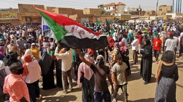 A Sudanese demonstrator waves a national flag during a protest against the October 2021 military coup, in the capital Khartoum, on January 13, 2022. (AFP)