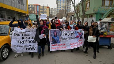 Afghan women march as they chant slogans and hold banners during a women's rights protest in Kabul on January 16, 2022. (Photo by Wakil KOHSAR / AFP)