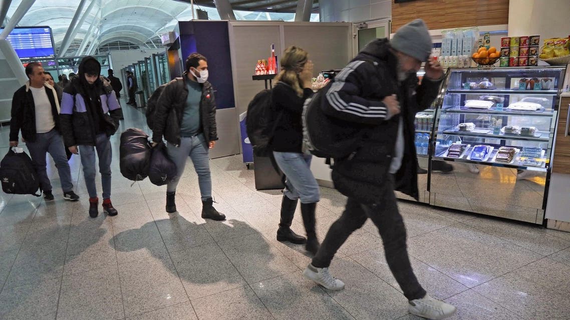 Iraqi migrants who were flown home from the Belarusian capital Minsk, arrive at the airport in Arbil, the capital of Iraq's northern autonomous Kurdish region, on November 26, 2021. (AFP)
