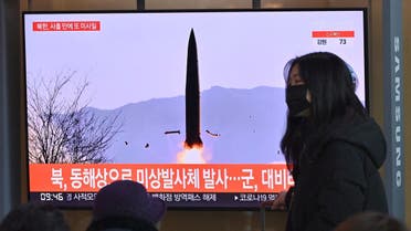 A woman walks past a television screen showing a news broadcast with file footage of a North Korean missile test, at a railway station in Seoul on January 17, 2022. (AFP)