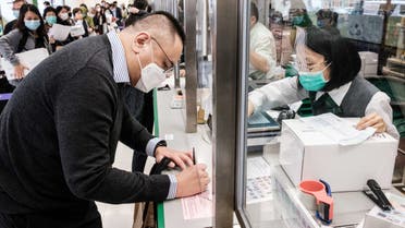Local resident Adrian W Chan, who works as a banker, prepares to post a parcel containing face masks for his parents in Vancouver, as a precautionary measure against the COVID-19 coronavirus, in Hong Kong on March 17, 2020. / AFP / ANTHONY WALLACE