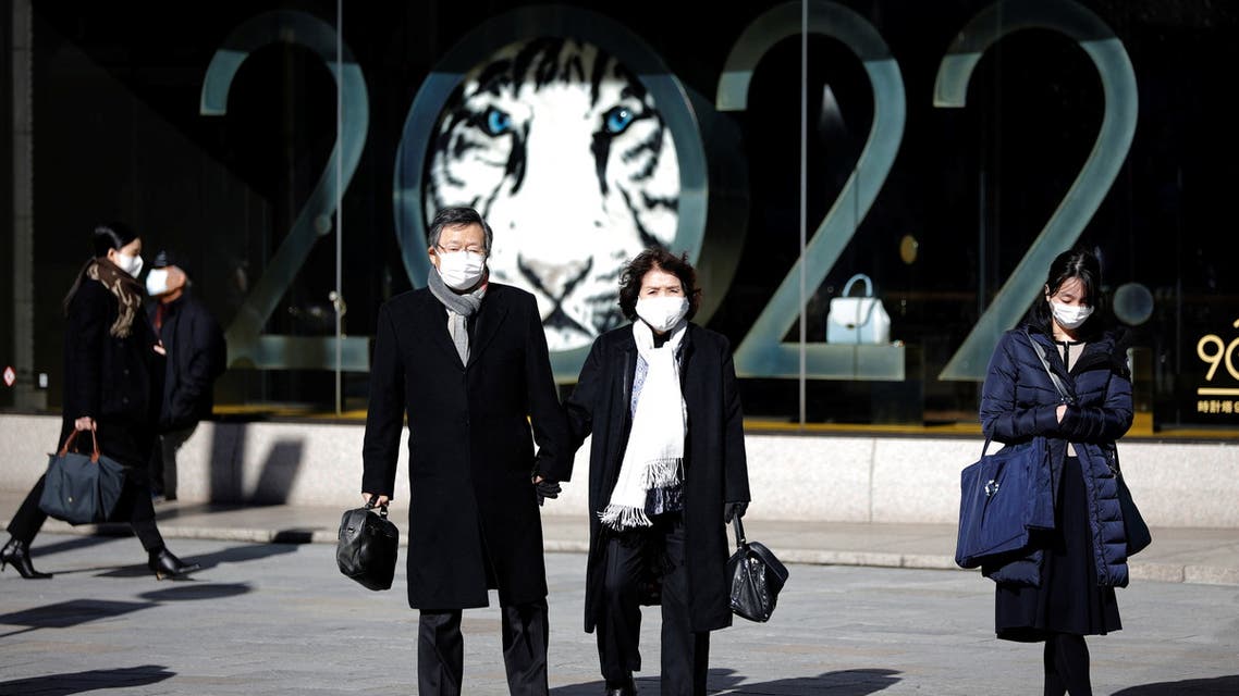 People wearing protective masks, amid the coronavirus disease (COVID-19) outbreak, stand in front of a show window of a department store at a shopping district in Tokyo, Japan, January 18, 2022. (Reuters)