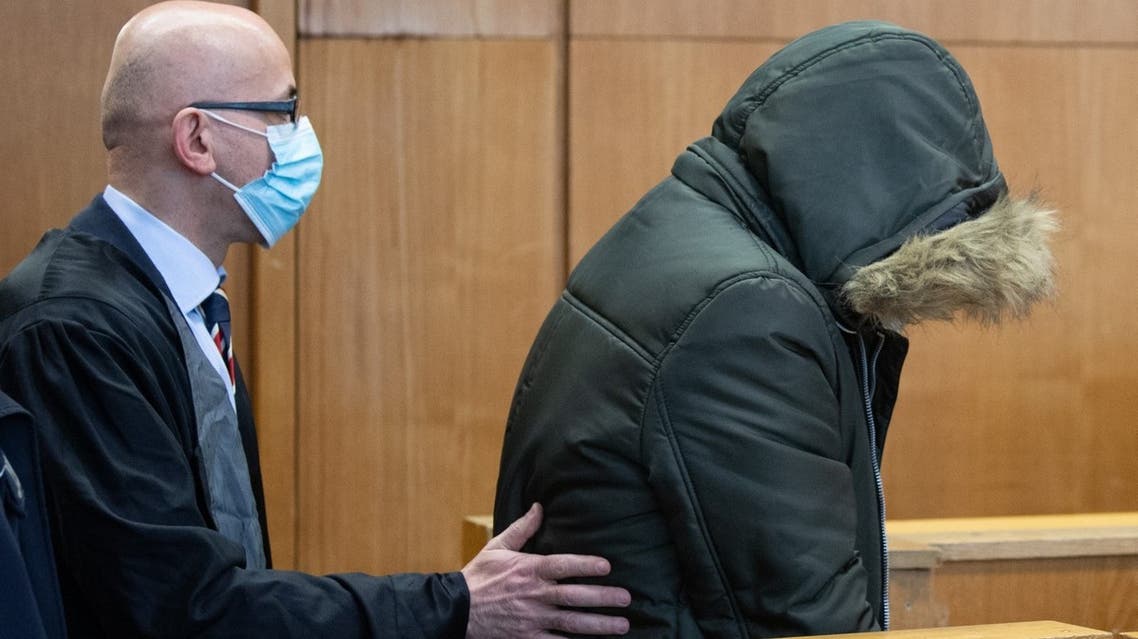 Defendant Alaa M (R), accused of crimes against humanity including torture and murder in his war-torn homeland Syria, walks next to his lawyer Oussama Al-Agi as he arrives on January 19, 2022 at court in Frankfurt am Main, western Germany. (AFP)