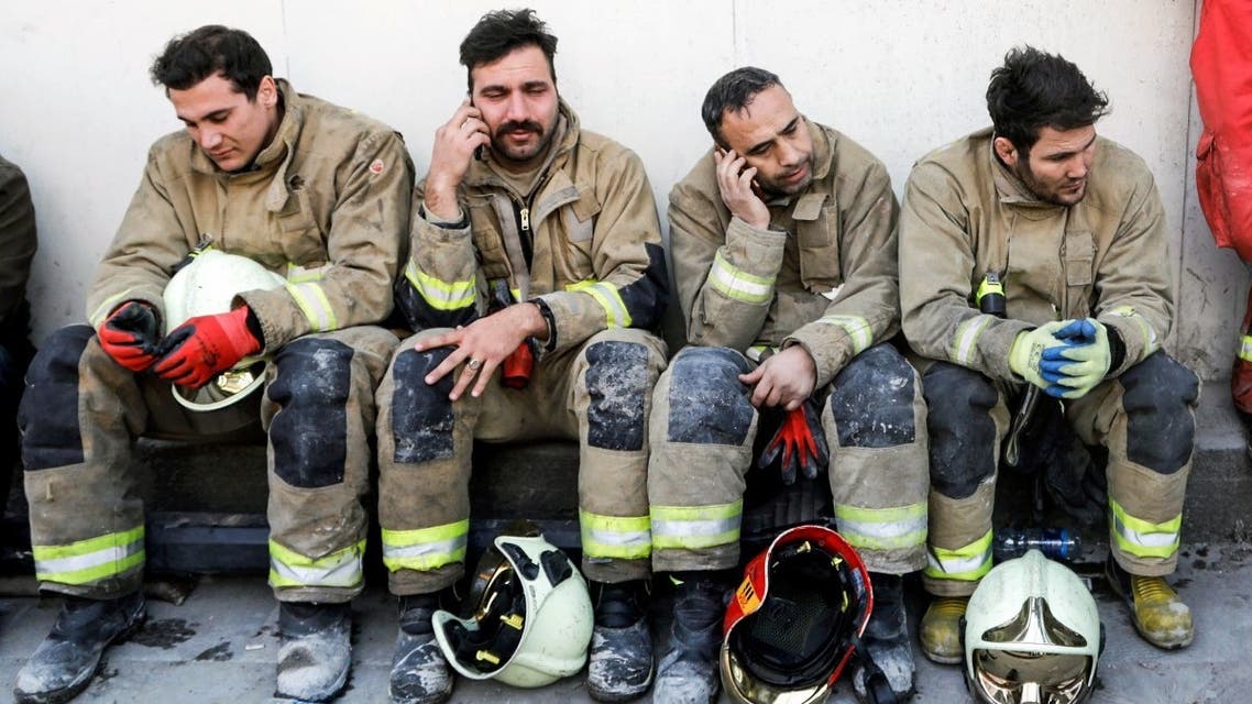 Iranian emergency personnel mourn for lost colleagues and friends as they sit in front of the wreckage of the 15-storey Plasco building which collapsed the previous day, on January 20, 2017, in the capital Tehran. (AFP)