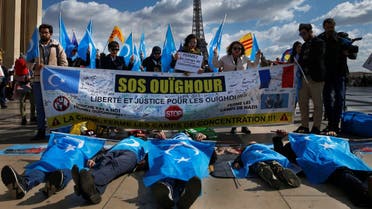 In this file photo taken on March 25, 2019, protesters of the French Uyghur Community shout slogans and hold flags of East Turkestan (or Uighur flags) during a demonstration over China's human rights record near the Eiffel Tower during a state visit of the Chinese president .  (AFP)