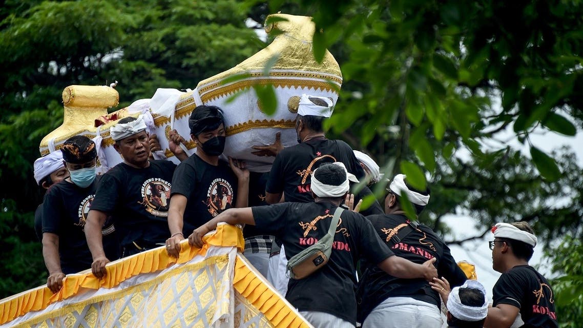 People carry the body of the late King Ida Cokorda Pemecutan XI of Bali, whose real name was Anak Agung Ngurah Manik Parasara, during the cremation ritual and ceremony in Denpasar on Indonesia's island of Bali on January 21, 2022. (AFP)