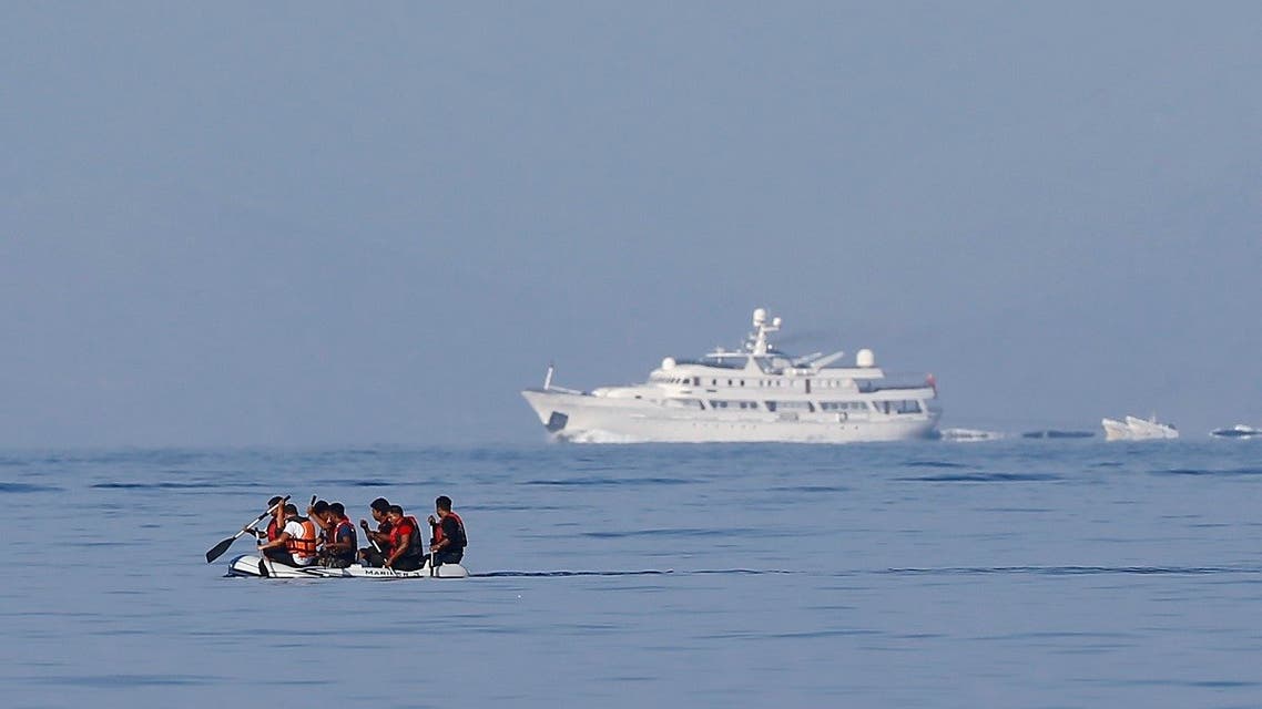 Migrants in a dinghy paddle past a luxury yacht which cruises on Mediterranean Sea as they attempt a crossing to the Greek island of Kos, off the shores of Bodrum, Turkey, September 19, 2015. (Reuters)