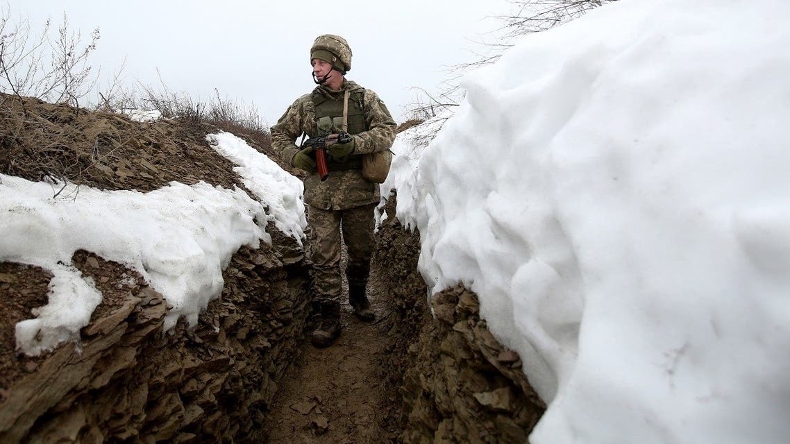 An Ukrainian Military Forces serviceman walks on a trench on the frontline with Russia-backed separatists near Luganske village, in Donetsk region on January 11, 2022. (AFP)