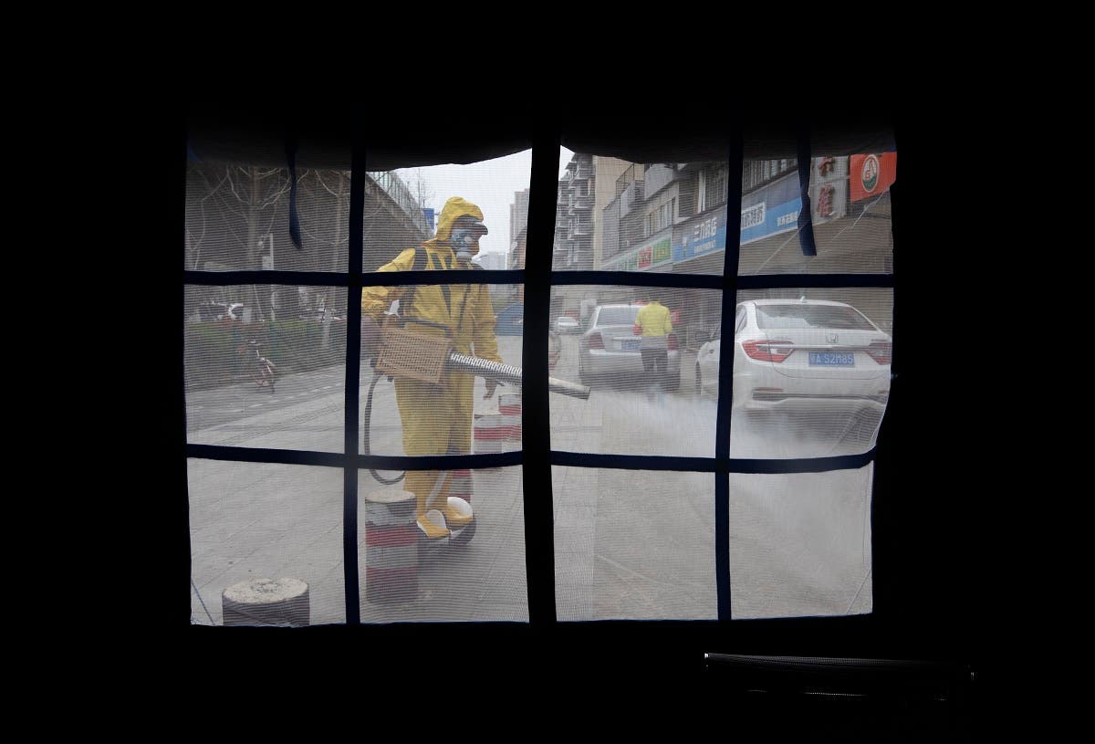 A volunteer disinfects a residential area amid the COVID-19 coronavirus outbreak in Wuhan in China's central Hubei province on March 16, 2020. (AFP)