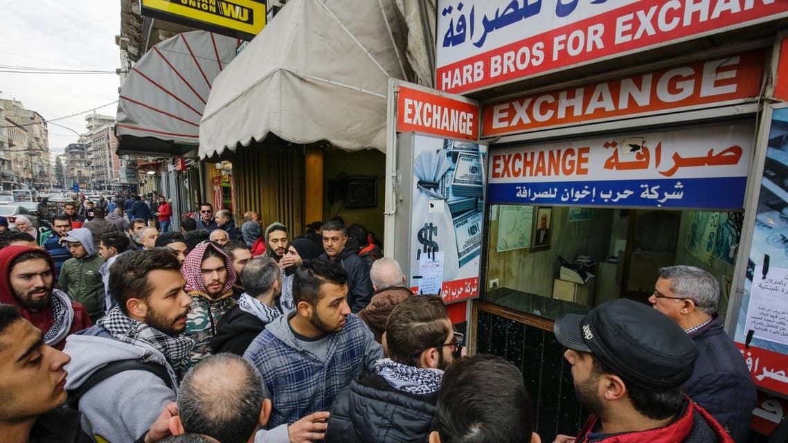 Lebanese anti-government protesters gather at the entrance of an exchange office asking its owner to stop USD exchange in the northern port city of Tripoli, on January 15, 2020. (AFP)