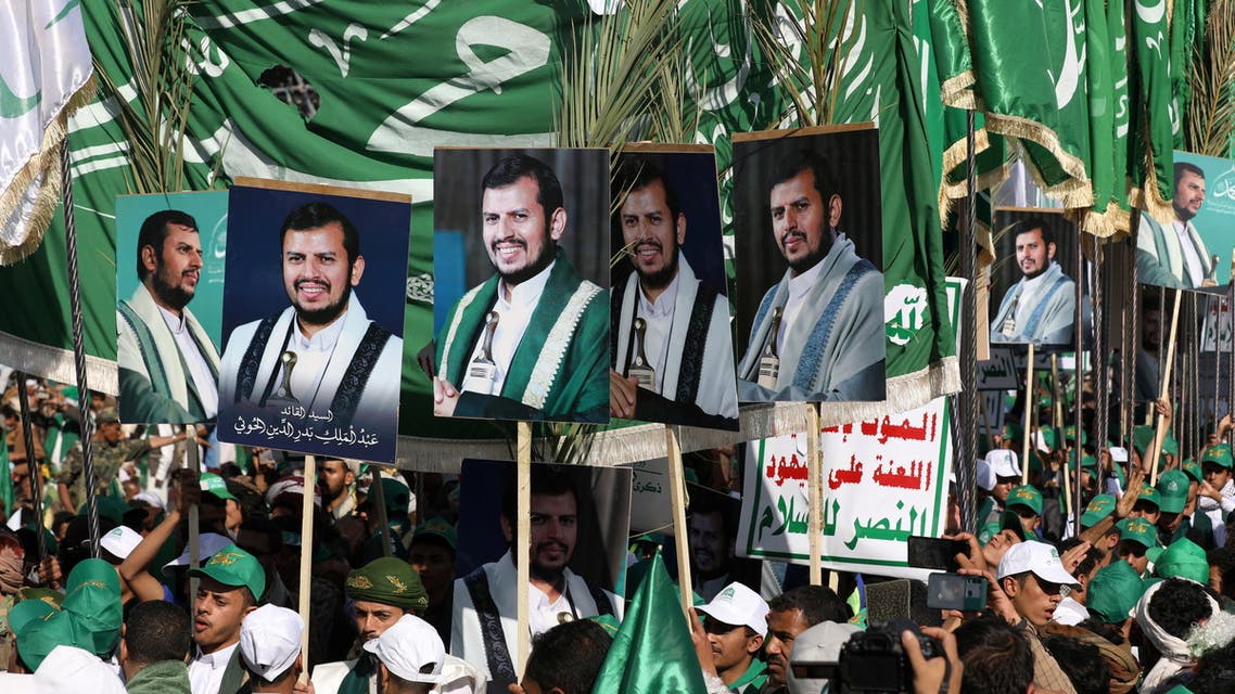 Houthi supporters hold up flags and posters of the Houthi leader Abdul-Malik Badruddin al-Houthi during a rally to mark the Prophet Muhammad's birthday in Sanaa, Yemen October 18, 2021. (Reuters)