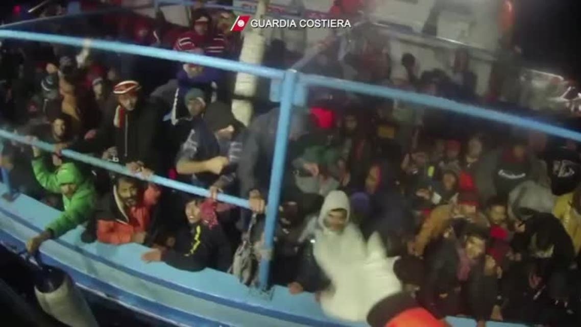 Italian coastguard members rescuing migrants from boat in distress off island of Lampedusa, January 25, 2022. (Reuters)
