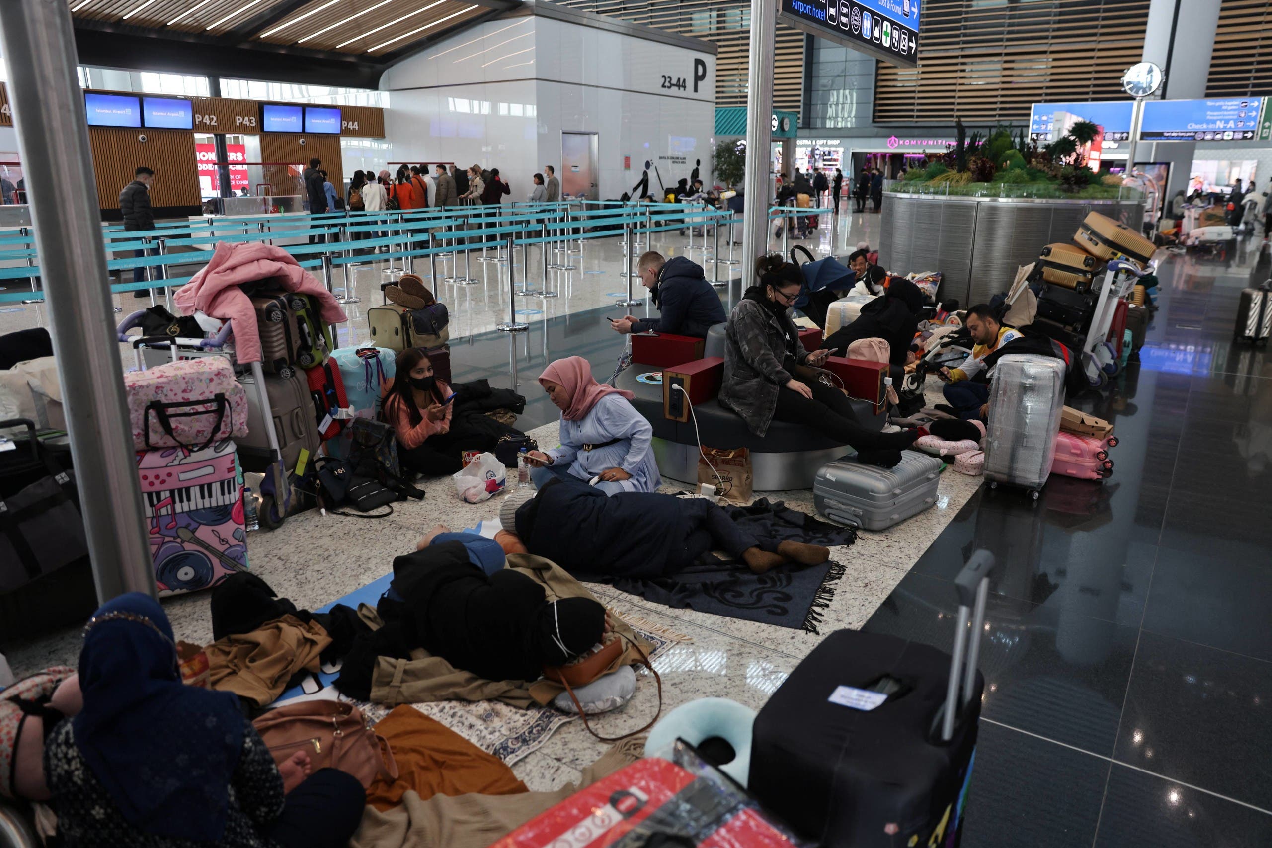 Stranded passengers wait for their flights at Istanbul airport, which is suspending flights due to heavy snowfall, in Istanbul, Turkey January 25, 2022. (Reuters)