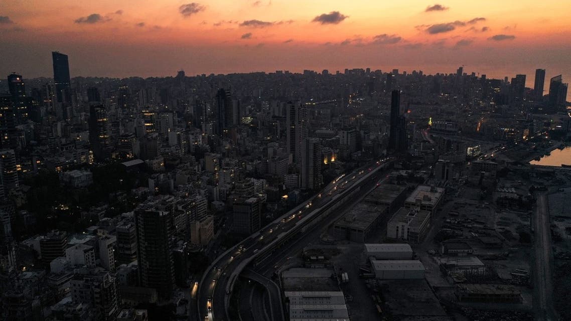 A dusk aerial view of cars driving by the devastated Port of Beirut, in darkness during a power outage. (File Photo: AFP)