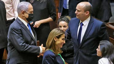 A file photo shows Israel’s outgoing prime minister Netanyahu shakes hands with his successor, incoming PM Bennett, after a special session to vote on a new government at the Knesset in Jerusalem, on June 13, 2021. (AFP)