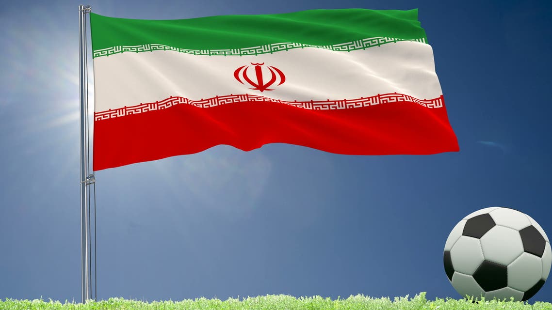 Flag of Iran fluttering and a football rolls on the lawn, 3d rendering. stock photo