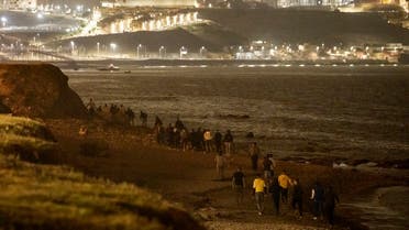 Moroccan migrants walk on the seashore as they attempt to cross the border from Morocco to Spain. (File Photo: AFP)