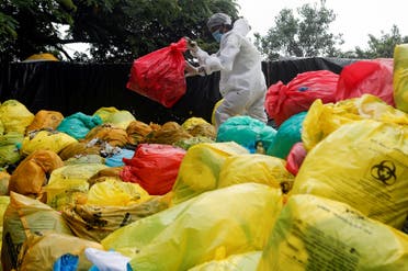 A man in personal protective equipment (PPE) clears bags filled with medical waste at a hospital, amid the spread of the coronavirus disease (COVID-19) in Mumbai, India, on August 11, 2020. (Reuters) 
