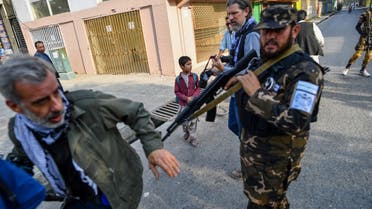 A member of the Taliban special forces pushes a journalist (L) covering a demonstration by women protestors outside a school in Kabul on September 30, 2021. (AFP)