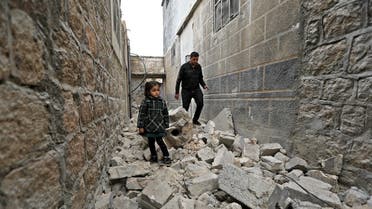 A man and a young girl walk on rubble in the Turkish-controlled city of al-Bab in Syria's northern Aleppo province on the border with Turkey on February 2, 2022, following reported artillery shelling. Eight people, including at least five civilians, died today in artillery shelling on a Turkish-held city in northern Syria, a war monitor reported, without specifying the source of the attack. Both regime and Kurdish led forces maintain a presence near the city. (Photo by Bakr ALKASEM / AFP)