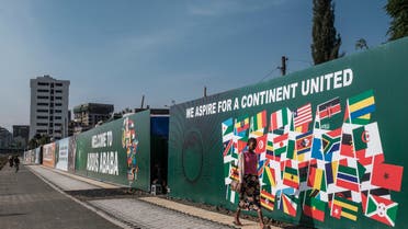 A man walks in front of a banner set as part of the preparations in the city for hosting the 35th ordinary summit of the African Union, in the city of Addis Ababa, Ethiopia, on February 01, 2022. (Photo by EDUARDO SOTERAS / AFP)  ethiopia - au - summit  ethiopia - au - summit  ethiopia - au - summit