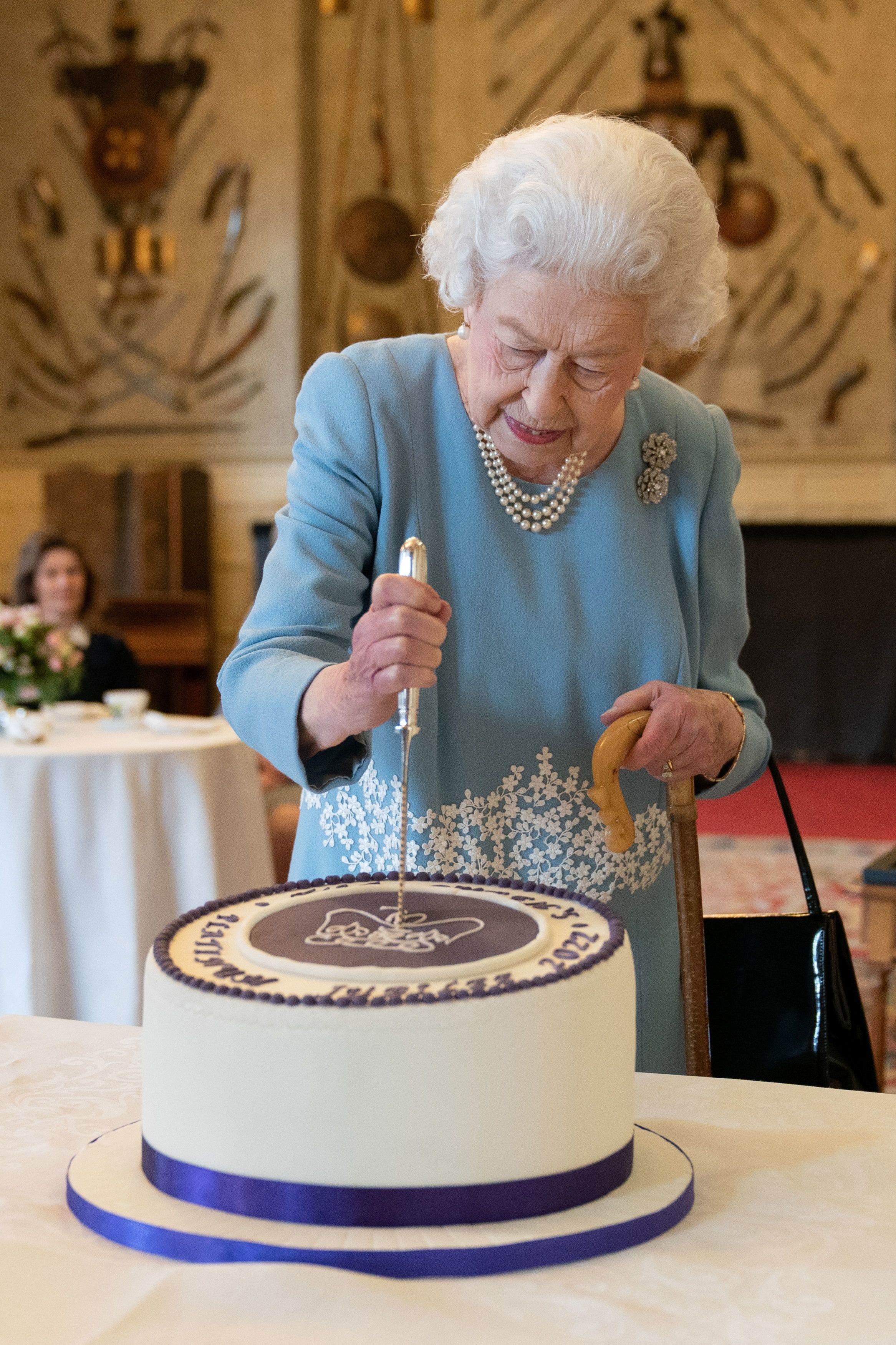 Britain's Queen Elizabeth cuts a cake to celebrate the start of the Platinum Jubilee during a reception in the Ballroom of Sandringham House, in Sandringham, Britain, February 5, 2022. (Reuters)