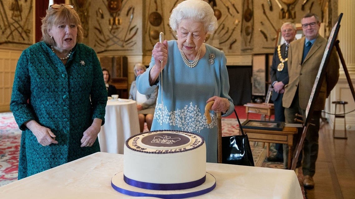 Britain’s Queen Elizabeth II cuts a cake to celebrate the start of the Platinum Jubilee during a reception in the Ballroom of Sandringham House, which is the Queen's Norfolk residence, in Sandringham, Britain, on February 5, 2022. (Reuters)