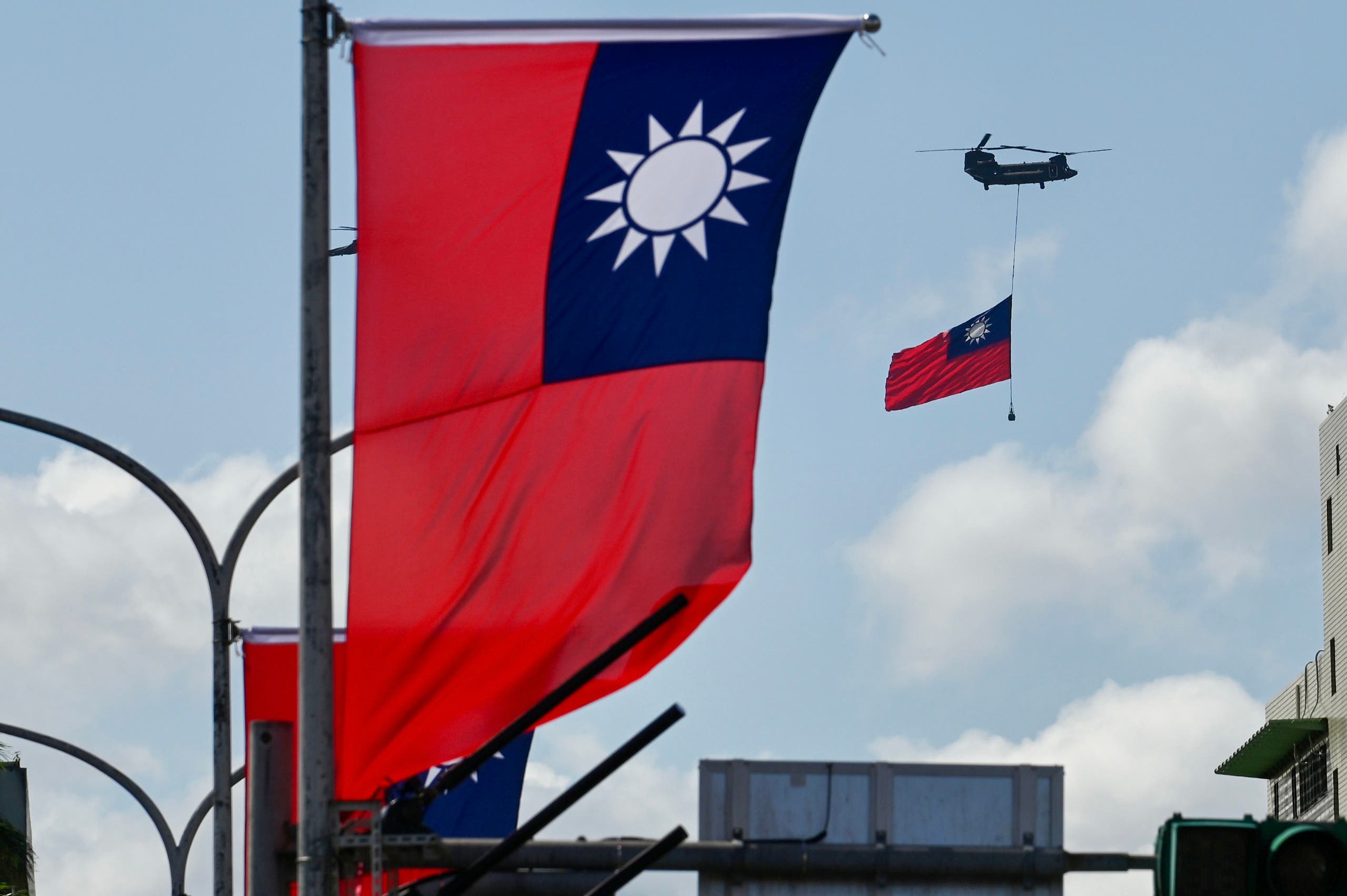 A CH-47 Chinook helicopter carries a Taiwan flag during national day celebrations in Taipei on Oct. 10, 2021. (AFP)