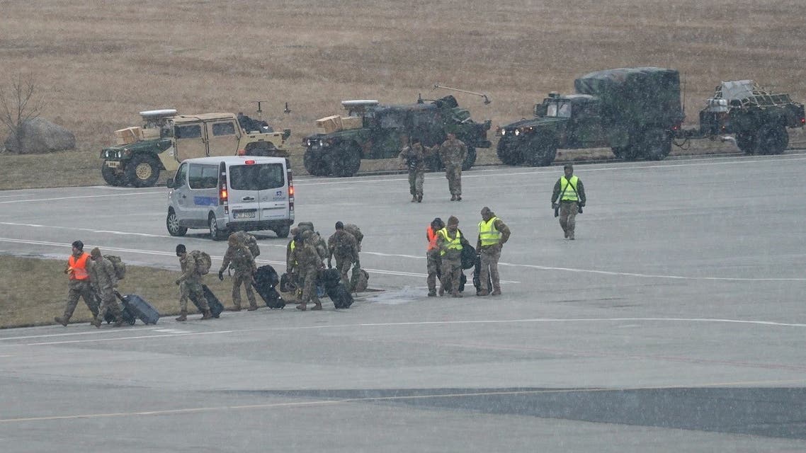 US troops walk from a US Air Force transport plane transporting military equipment and troops after landing at the Rzeszow-Jasionka airport in southeastern Poland, on February 6, 2022. (AFP)