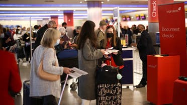 People have their travel documents checked as they queue to check into a Virgin Atlantic flight at Heathrow Airport Terminal 3. (Reuters) 