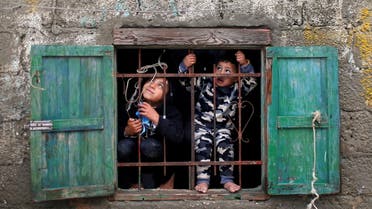 Palestinian children look out of their family's home window on a rainy day at Deir al-Balah refugee camp in the central Gaza Strip December 17, 2020. (File photo: Reuters)