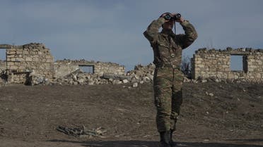 An ethnic Armenian soldier looks through binoculars as he stands at fighting positions near the village of Taghavard in the region of Nagorno-Karabakh, January 11, 2021. Picture taken January 11, 2021. (File photo: Reuters)