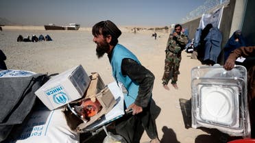 FILE PHOTO: An UNHCR worker pushes a wheelbarrow loaded with aid supplies for a displaced Afghan family in Kabul, Oct. 28, 2021. (Reuters)