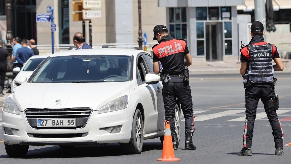 Police officers halt a vehicle as they check for intercity travel documentation on a street in Ankara on May 1, 2021. (AFP)