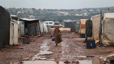 Internally displaced Syrian woman walks through mud between tents after heavy rain at Kafr Arouk camp in Idlib, Syria December 20, 2021. Picture taken December 20, 2021. (File photo: Reuters)