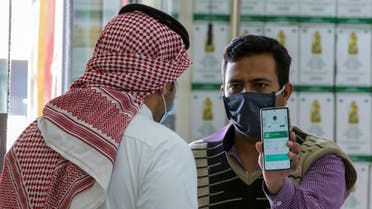 A man displays his details on his mobile phone using the Tawakkalna app, which was launched by Saudi authorities to as a precaution against COVID-19, as he enters the Al-Othaim market in Riyadh, Saudi Arabia February 22, 2021. (Reuters)