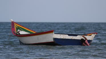 A girl holds a boat while playing at La Salina area from where Maroly Bastardo, an eight months pregnant woman, along with her children, her husband's sister, uncle and father, boarded a smuggler's boat and disappeared in the Caribbean Sea during an attempt to cross from Venezuela to Trinidad and Tobago, in Guiria, Venezuela, May 24, 2019. (Reuters)