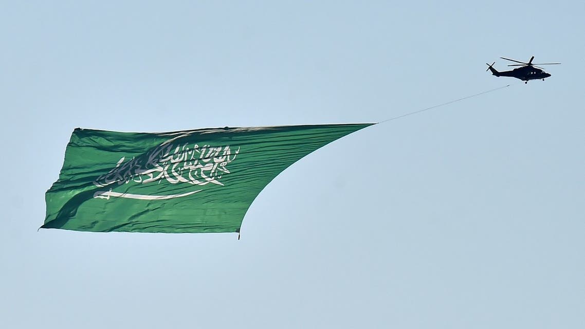 A military helicopter, carrying a huge national flag, flies over Riyadh during celebrations marking Saudi Arabi's 90th National Day on September 23, 2020. (AFP)