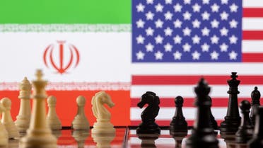 Chess pieces are seen in front of displayed Iran and US flags. (Reuters)