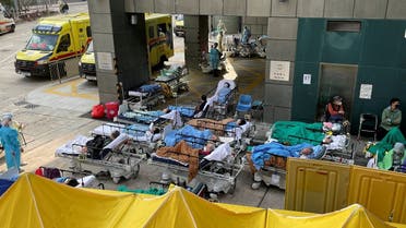 Patients wearing face masks lie in bed at a makeshift treatment area outside a hospital, following the coronavirus disease (COVID-19) outbreak in Hong Kong, China February 16, 2022. (Reuters) 