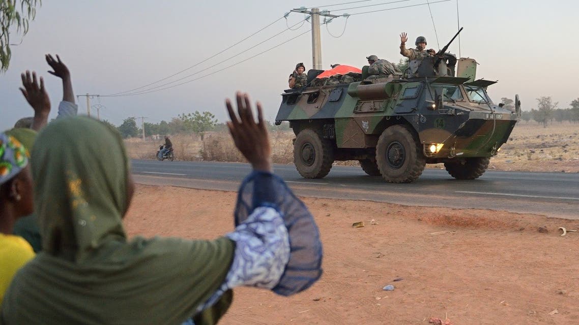 This file photo taken on January 15, 2013 shows Malian people waving to French soldiers as a convoy of armoured vehicles leave Bamako and start a deployment to the north of Mali as part of the Serval operations. (AFP)