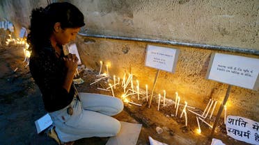 This file photo taken on July 29, 2008 shows a woman paying her respects next to a display of lighted candles near the Trauma Centre of the Civil Hospital in Ahmedabad, after the deaths of dozens of people on July 26 in a series of bombings. (AFP)