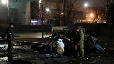 Specialists inspect a wreckage of a car that, according to the local authorities, was blown up near the government building, in the rebel-controlled city of Donetsk, Ukraine February 18, 2022. (Reuters)