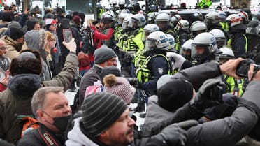 Police face off with demonstrators participating in a protest organized by truck drivers opposing vaccine mandates on February 19, 2022 in Ottawa, Canada. (AFP)