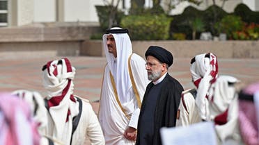 A handout picture released by the Qatar Amiri Diwan shows Qatar’s Emir Sheikh Tamim bin Hamad al-Thani (L) receiving Iranian President Ebrahim Raisi upon his arrival to Qatar on February 21, 2022. (AFP)              