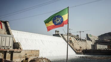 This general view shows an Ethiopian national flag flying infront of the Grand Ethiopian Renaissance Dam (GERD) in Guba, Ethiopia, on February 19, 2022. Ethiopia's massive hydro-electric dam project on a tributary of the Nile has raised regional tensions notably with Egypt, which depends on the huge river for 97 percent of its water supply.