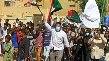 Sudanese demonstrators wave their country's national flag during ongoing protests calling for civilian rule and denouncing the military administration, in the city of Khartoum North near the capital on February 21, 2022. (AFP)
